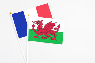 Wales and France stick flags on white background. High quality fabric, miniature national flag. Peaceful global concept.White floor for copy space.