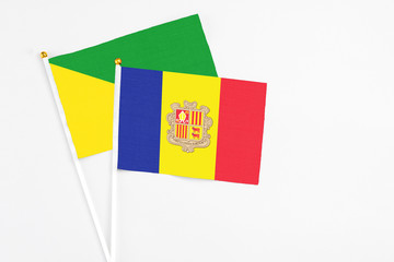 Andorra and French Guiana stick flags on white background. High quality fabric, miniature national flag. Peaceful global concept.White floor for copy space.