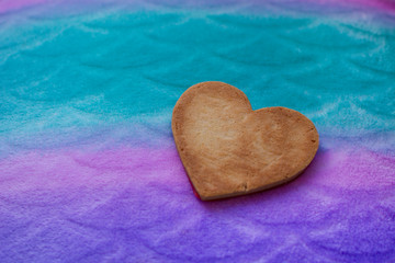 Heart-shaped cookie isolated on a colorful background.