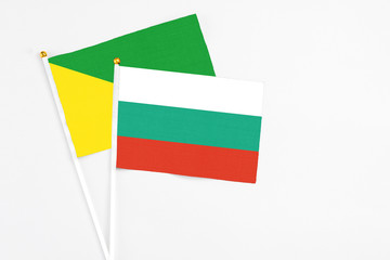 Bulgaria and French Guiana stick flags on white background. High quality fabric, miniature national flag. Peaceful global concept.White floor for copy space.