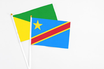 Congo and French Guiana stick flags on white background. High quality fabric, miniature national flag. Peaceful global concept.White floor for copy space.