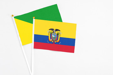 Ecuador and French Guiana stick flags on white background. High quality fabric, miniature national flag. Peaceful global concept.White floor for copy space.