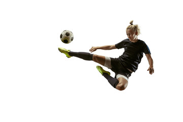 Young female soccer or football player with long hair in sportwear and boots kicking ball for the goal in jump on white background. Concept of healthy lifestyle, professional sport, motion, movement.
