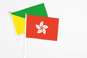 Hong Kong and French Guiana stick flags on white background. High quality fabric, miniature national flag. Peaceful global concept.White floor for copy space.