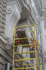 Workers restore the facade of an building