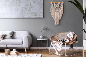 Modern boho interior design of sitting room with design rattan armchair, gray sofa, coffee table,...
