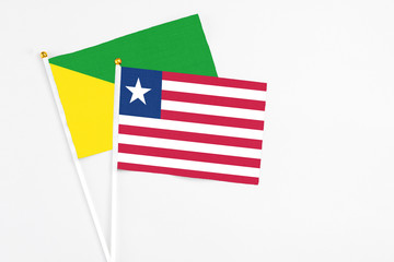 Liberia and French Guiana stick flags on white background. High quality fabric, miniature national flag. Peaceful global concept.White floor for copy space.