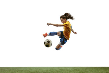Young female soccer or football player with long hair in sportwear and boots kicking ball for the goal in jump on white background. Concept of healthy lifestyle, professional sport, motion, movement. © master1305