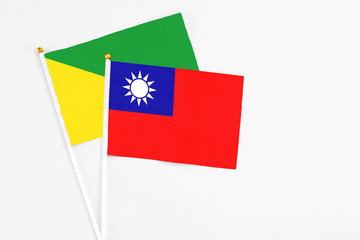 Taiwan and French Guiana stick flags on white background. High quality fabric, miniature national flag. Peaceful global concept.White floor for copy space.