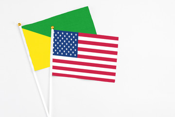United States and French Guiana stick flags on white background. High quality fabric, miniature national flag. Peaceful global concept.White floor for copy space.
