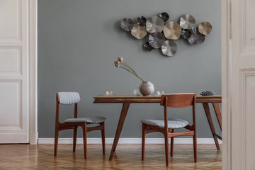 Modern and stylish dining room interior with glamour wooden table , elegant chairs and design...