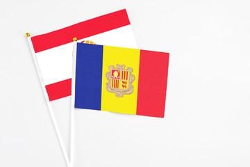 Andorra and French Polynesia stick flags on white background. High quality fabric, miniature national flag. Peaceful global concept.White floor for copy space.