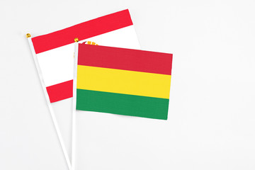 Bolivia and French Polynesia stick flags on white background. High quality fabric, miniature national flag. Peaceful global concept.White floor for copy space.