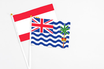 Fototapeta premium British Indian Ocean Territory and French Polynesia stick flags on white background. High quality fabric, miniature national flag. Peaceful global concept.White floor for copy space.