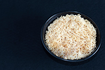 Noodles in a black bowl..Popular in Asia, ready to eat on a black background. Restaurant business concept.