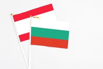 Bulgaria and French Polynesia stick flags on white background. High quality fabric, miniature national flag. Peaceful global concept.White floor for copy space.