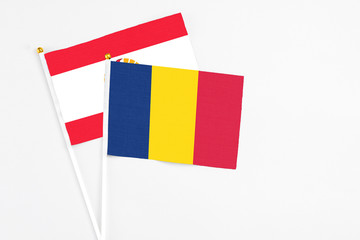 Chad and French Polynesia stick flags on white background. High quality fabric, miniature national flag. Peaceful global concept.White floor for copy space.