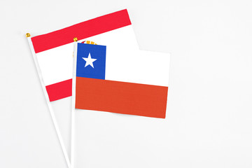 Chile and French Polynesia stick flags on white background. High quality fabric, miniature national flag. Peaceful global concept.White floor for copy space.