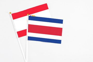 Costa Rica and French Polynesia stick flags on white background. High quality fabric, miniature national flag. Peaceful global concept.White floor for copy space.