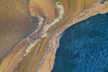 Abstract picture of a brown floating surface layer on blue water