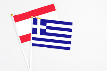 Greece and French Polynesia stick flags on white background. High quality fabric, miniature national flag. Peaceful global concept.White floor for copy space.