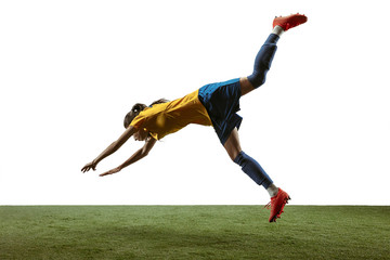 Fototapeta na wymiar Young female soccer or football player with long hair in sportwear and boots kicking ball for the goal in jump on white background. Concept of healthy lifestyle, professional sport, motion, movement.