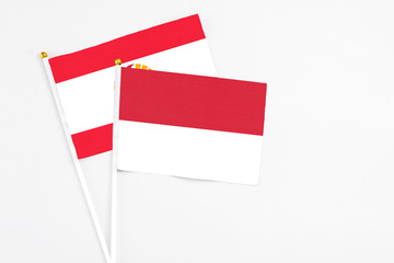 Indonesia and French Polynesia stick flags on white background. High quality fabric, miniature national flag. Peaceful global concept.White floor for copy space.