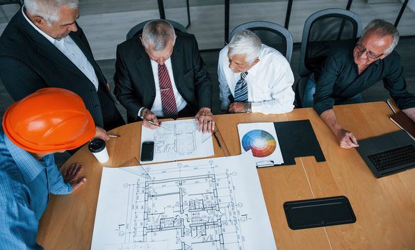 Aged team of elderly businessman architects have a meeting in the office