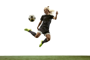 Young female soccer or football player with long hair in sportwear and boots kicking ball for the goal in jump on white background. Concept of healthy lifestyle, professional sport, motion, movement.