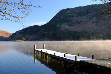 A frosted jetty leads into a still lake