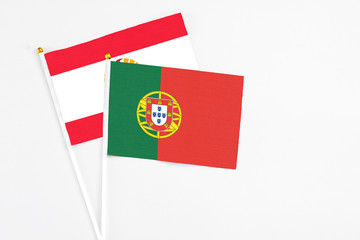 Portugal and French Polynesia stick flags on white background. High quality fabric, miniature national flag. Peaceful global concept.White floor for copy space.