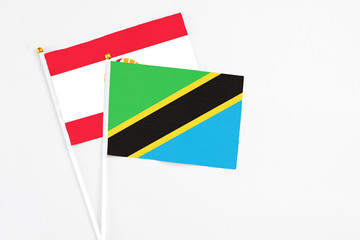 Tanzania and French Polynesia stick flags on white background. High quality fabric, miniature national flag. Peaceful global concept.White floor for copy space.