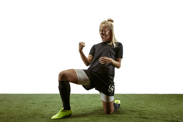 Young female soccer or football player with long hair in sportwear and boots training on white...