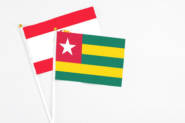 Togo and French Polynesia stick flags on white background. High quality fabric, miniature national flag. Peaceful global concept.White floor for copy space.