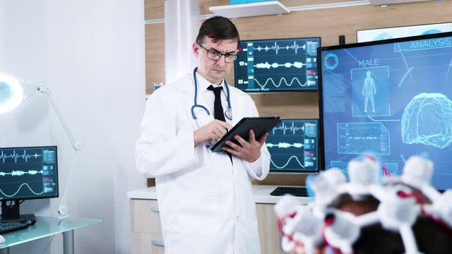 Doctor in a modern neuroscience centre making notes on tablet