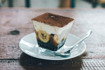 Close up view of Banoffee pie on the plate with wooden table.