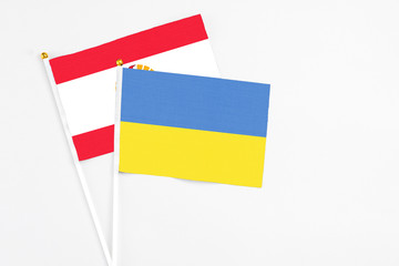 Ukraine and French Polynesia stick flags on white background. High quality fabric, miniature national flag. Peaceful global concept.White floor for copy space.