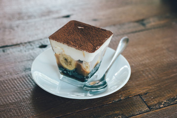 Close up view of Banoffee pie on the plate with wooden table.