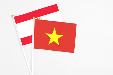 Vietnam and French Polynesia stick flags on white background. High quality fabric, miniature national flag. Peaceful global concept.White floor for copy space.