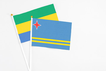 Aruba and Gabon stick flags on white background. High quality fabric, miniature national flag....