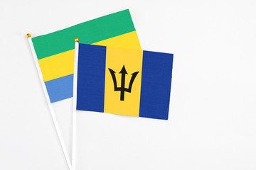 Barbados and Gabon stick flags on white background. High quality fabric, miniature national flag....