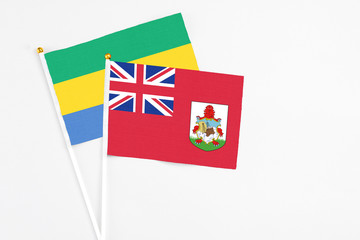 Bermuda and Gabon stick flags on white background. High quality fabric, miniature national flag....