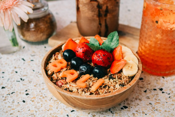 Healthy breakfast bowl with fresh berries, nuts, bananas and chocolate smoothie drink. Vegan food.