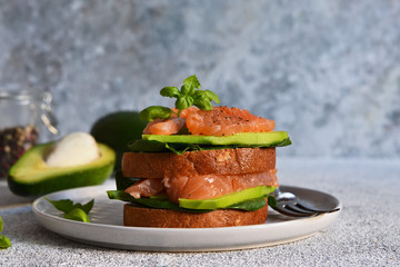 Rye bread sandwich with avocado and salmon. Horizontal.