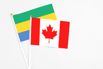 Canada and Gabon stick flags on white background. High quality fabric, miniature national flag....