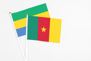 Cameroon and Gabon stick flags on white background. High quality fabric, miniature national flag. Peaceful global concept.White floor for copy space.