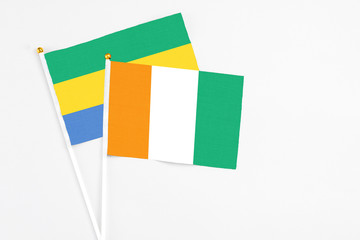 Cote D'Ivoire and Gabon stick flags on white background. High quality fabric, miniature national...