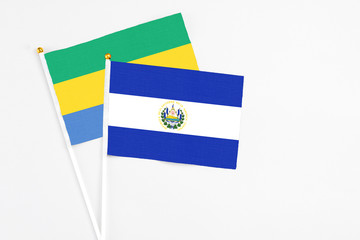 El Salvador and Gabon stick flags on white background. High quality fabric, miniature national...