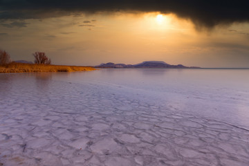 Winter day with frozen lake Balaton in Hungary in sunset light