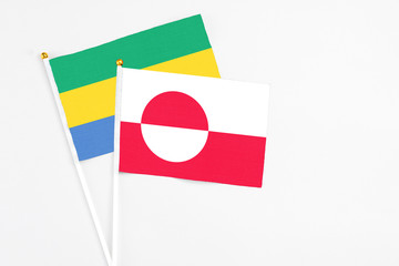 Greenland and Gabon stick flags on white background. High quality fabric, miniature national flag....